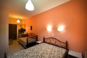 a bedroom with two beds and orange walls at House Anna Sarti in Sarti