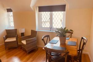 a dining room with a wooden table and chairs at Over The Arches, Chipping Campden in Chipping Campden