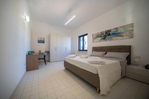 ein Schlafzimmer mit einem Bett und einem Schreibtisch. in der Unterkunft Elegante Villa tra Mare e Storia in Paestum