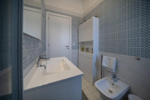 ein weißes Bad mit einem Waschbecken und einem WC in der Unterkunft Elegante Villa tra Mare e Storia in Paestum