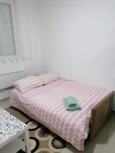 a bedroom with a bed with a green hat on it at Apartman Holand in Banja Koviljača