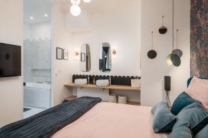 a bedroom with a large bed and a tv at Le Cocon Hygge & SPA in Lyon