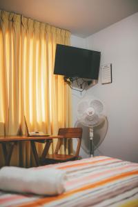 una camera con letto, scrivania e ventilatore di Hotel Excalibur a Lima