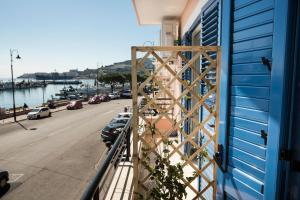 a balcony with a blue building and a street at Acquazzurra Gaeta in Gaeta