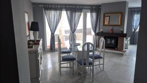 a dining room with a glass table and chairs at Apartamento Puerto Marina in Benalmádena