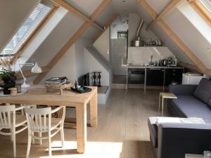 BBOosterweg3 Studio في هيمسكيرك: غرفة معيشة مع طاولة خشبية ومطبخ
