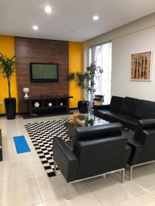 a living room with black furniture and a flat screen tv at Tri Hotel Centro Chapecó in Chapecó