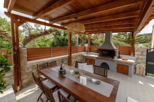 a patio with a table and an outdoor oven at Villa Kalliopi in Prinés