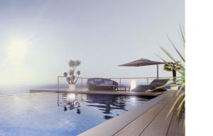 a swimming pool with two chairs and an umbrella at Monaco view, pool, garage, 100 m2 terrace in Beausoleil