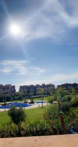 a park with a palm tree and buildings in the background at Prestigia Golf in Marrakesh