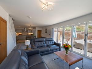 a living room with a blue couch and a table at Lemonade Cottage in Whitby