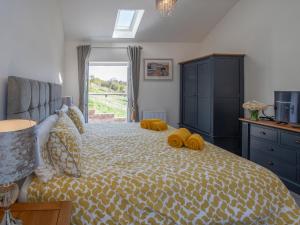 a bedroom with a bed with yellow pillows on it at Lemonade Cottage in Whitby