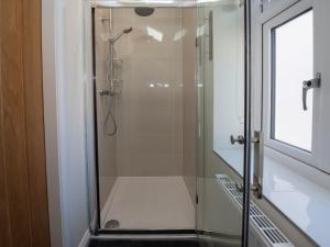 a shower with a glass door in a bathroom at Lemonade Cottage in Whitby +20 photos