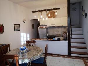 a kitchen and dining room with a table and a kitchen and stairs at Il Pastore Serafino in Tropea
