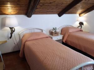 Un dormitorio con dos camas y una mesa con lámpara. en Il Pastore Serafino, en Tropea