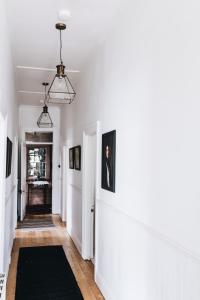 戴爾斯福特的住宿－The Main House @ Poets Lodge，一条带白色墙壁和黑色地毯的走廊