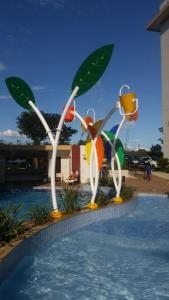 a swimming pool with a statue of fruits and vegetables at Privé Marina flat Apart in Caldas Novas