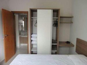 a bedroom with a bed and a closet with towels at Privé Marina flat Apart in Caldas Novas