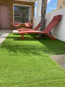 a red bench on the grass in a yard at EBLI House in San Miguel de Salinas