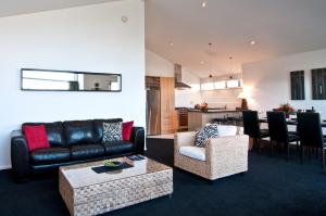a living room with a couch and a table at Distinction Wanaka Alpine Resort in Wanaka