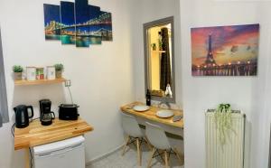 een kamer met een bureau, een tafel en een spiegel bij George Airport Apartments in Heraklion