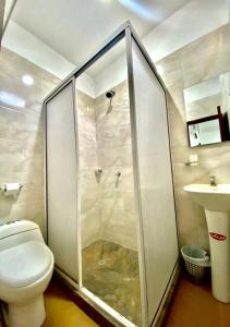 a bathroom with a shower stall and a toilet at Hostal Aurora, Smith Lodging in Taganga