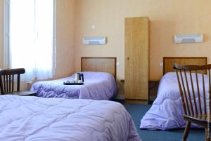 Cette chambre comprend 2 lits avec des draps violets. dans l'établissement Le Clos Normand, à Troarn