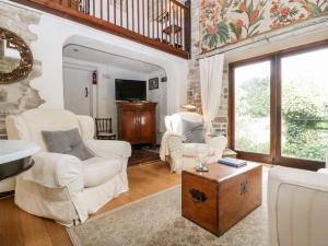 uma sala de estar com mobiliário branco e uma parede de pedra em The Granary em Edington
