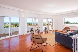a living room with a couch and some windows at Villa Benagil Boutique by Algarve Vacation in Carvoeiro