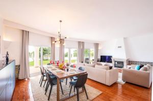 a dining room and living room with a table and chairs at Villa Benagil Boutique by Algarve Vacation in Carvoeiro