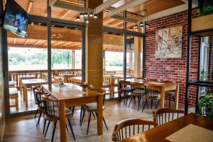 a restaurant with wooden tables and chairs and a brick wall at Heaven Lux Ulcinj in Ulcinj