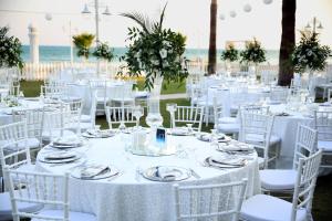 a set up for a wedding with white tables and chairs at Sahil Martı Hotel in Mezitli