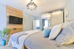 ein Schlafzimmer mit einem großen Bett mit einem Kronleuchter in der Unterkunft PIA Apartment in Zadar