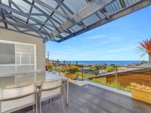 een patio met uitzicht op de oceaan vanuit een huis bij Rendezvous Gerringong in Gerringong