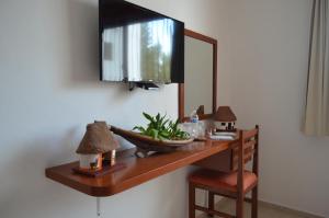 mesa con espejo y TV en la pared en Hotel Real Mercedes en Mérida