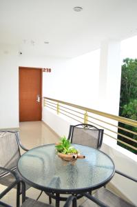 a glass table and chairs on a balcony at Hotel Real Mercedes in Mérida