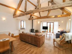 ein Wohnzimmer mit Sofa und Tisch in der Unterkunft Hill Farm Cottage in Bacton