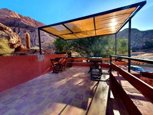a patio with a table and chairs and mountains at La Valentina in Purmamarca +39 photos