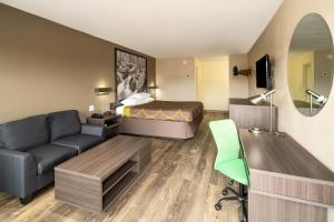 a hotel room with a bed and a couch at Super 8 by Wyndham Cleveland in Cleveland