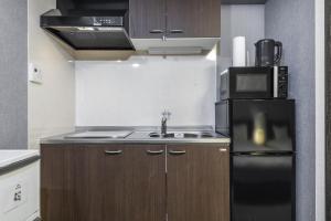 a kitchen with a black refrigerator and a sink at Tofukuji Riverside in Kyoto