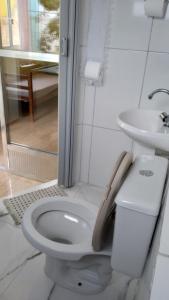 a white bathroom with a toilet and a sink at Alta Vista in Penedo +81 photos
