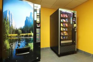 ein Getränkeautomat in einem Zimmer mit einem Gemälde in der Unterkunft Days Inn by Wyndham Black River Falls - Access to ATV Trail in Black River Falls