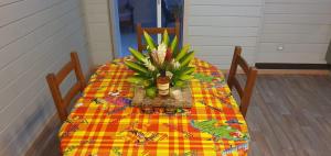 a table with a vase of flowers on it at Les Bungalows Couleurs Soleil in Le Vauclin