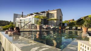 dos personas en una piscina en una casa en Quinta de San Amaro Rias Baixas, en Meaño