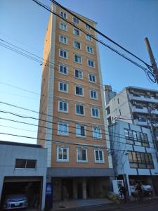 un grand bâtiment au milieu de deux bâtiments dans l'établissement ケイアイコンホテルズ 新栄301, à Aoichō