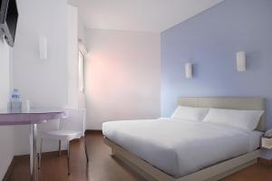 a white bedroom with a bed and a desk at Amaris Hotel Juanda in Jakarta +16 photos
