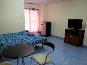 um quarto com uma cama, uma mesa e uma televisão em S.K. Residence em Bangkok