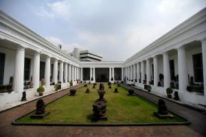a large white building with a courtyard with plants at Amaris Hotel Juanda in Jakarta