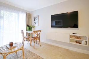 uma sala de estar com uma mesa e uma televisão na parede em Bay of Palms em Gold Coast