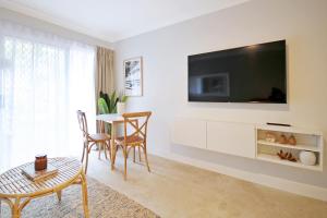 sala de estar con mesa y TV en la pared en Bay of Palms, en Gold Coast